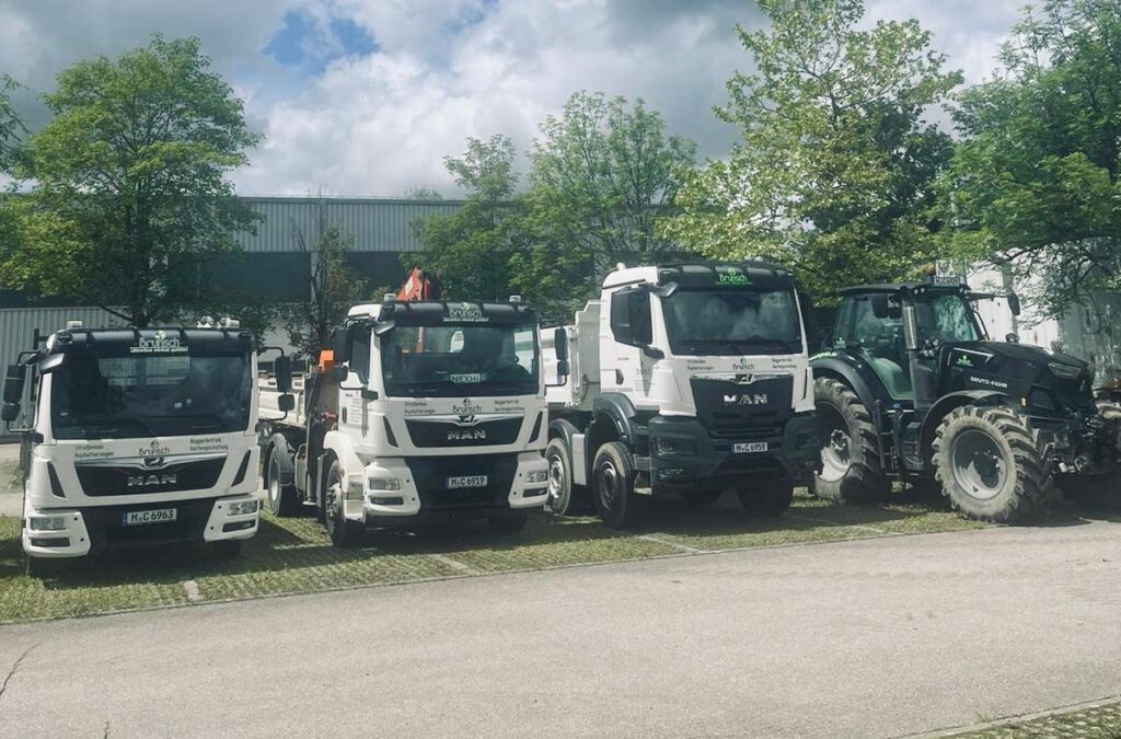 Moderner Fuhrpark der Florian Brunsch GmbH in Straßlach mit einer Auswahl an LKW wie 4-Achser Kipper, 2-Achser mit Kran und Abrollkipper, bereit für den Einsatz.
